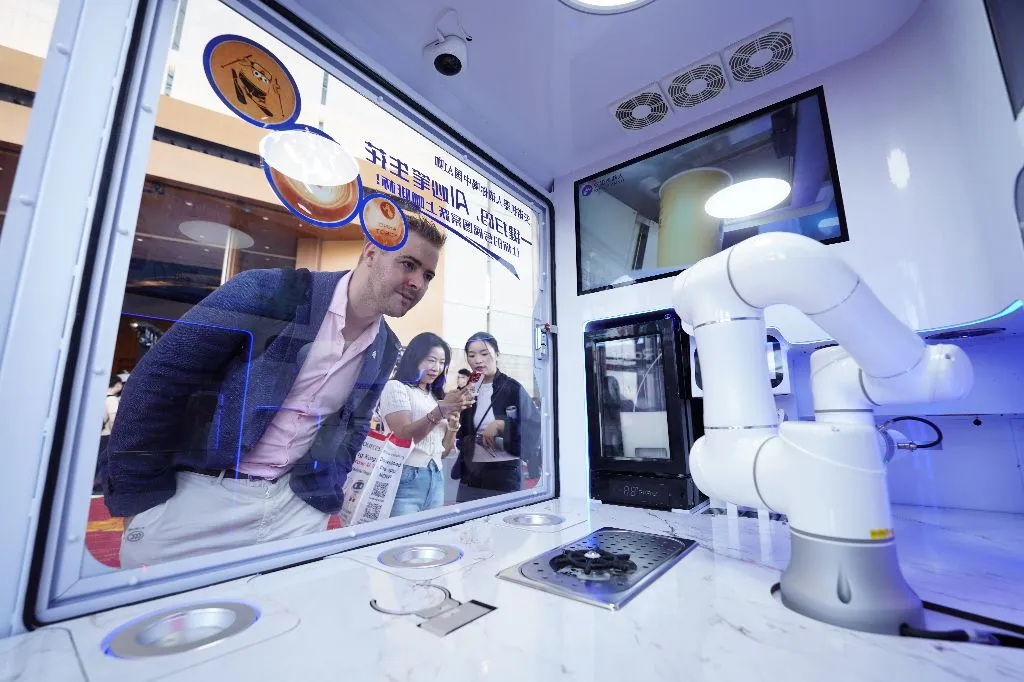 Visitors watching a robot arm demo at the 2025 fair