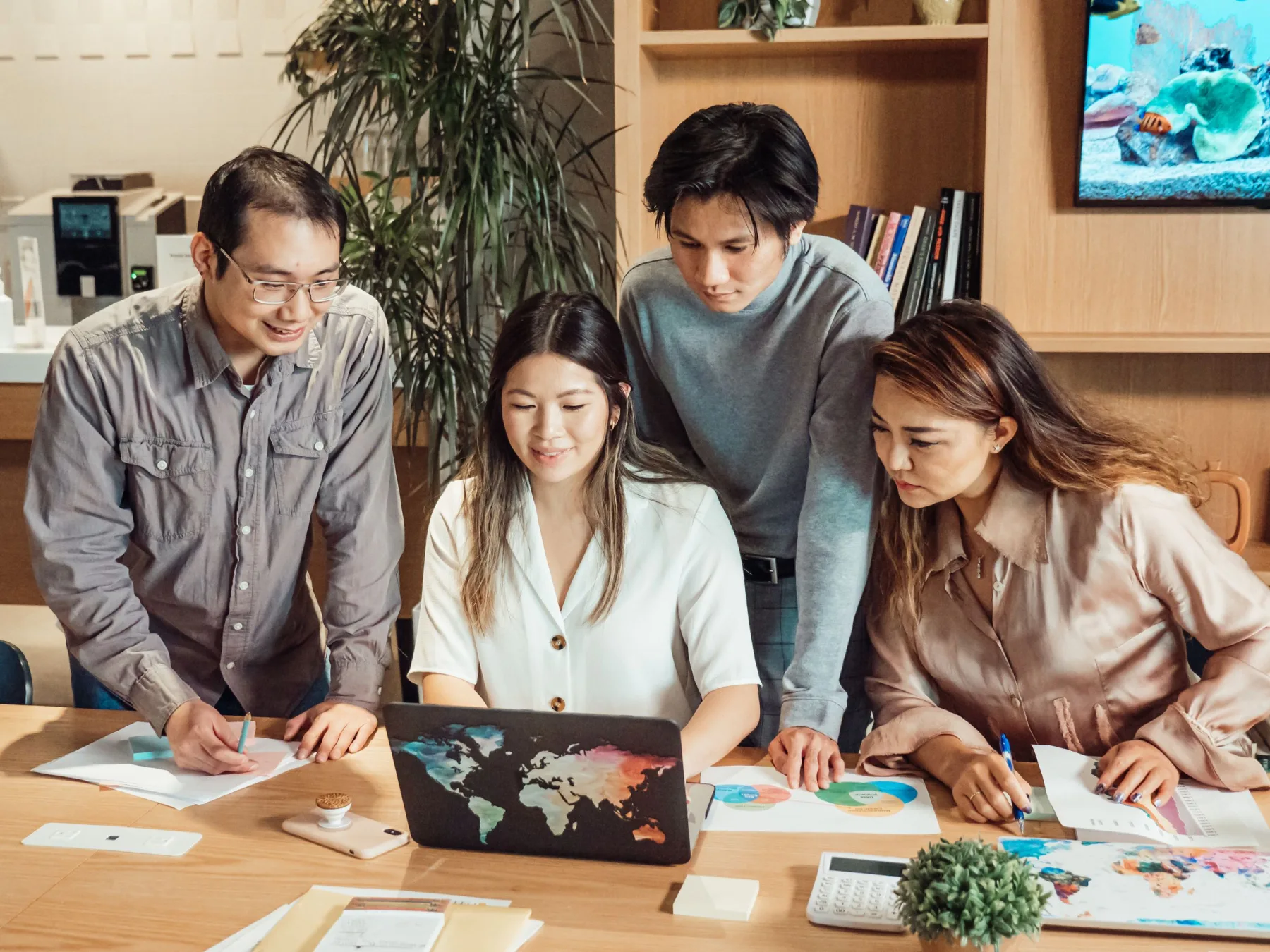 A team reviewing project data together around a laptop